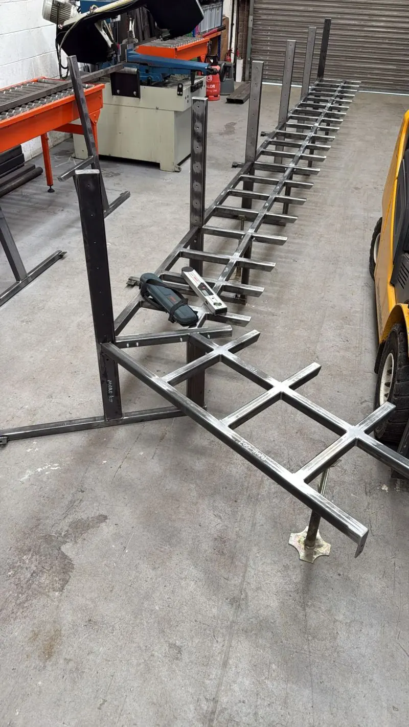 Part-fabricated steel bench terrace frame in a workshop.